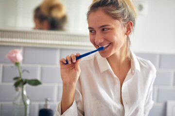Charming blond woman brushing teeth