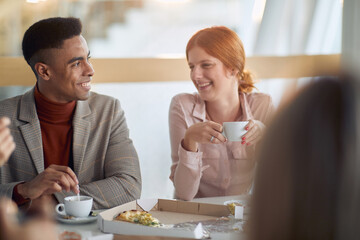 Employees enjoying coffee together at lunch break at company canteen. People, job, company, business concept.