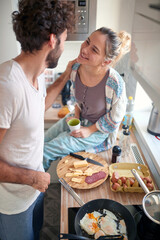 A young couple in love having romantic moments while preparing a breakfast together. Cooking, together, kitchen, relationship