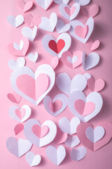 Valentine's Day festive background with pink and white paper hearts on a pink background for Valentines  holiday. Flatlay. Top view. Copyspace.
