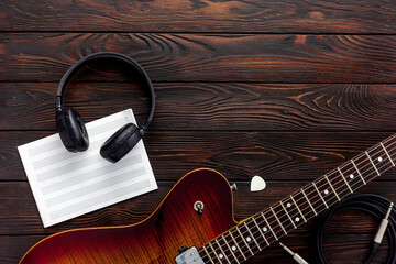 Naklejka premium Beautiful electric guitar on with headphones and coffee desktop