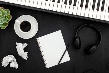 Desk of musician for songwriter work set with headphones and synthesizer