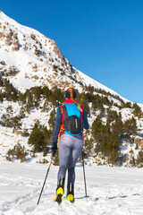 Fototapeta na wymiar Woman in the mountains practicing mountain skiing in the Pyrenees of Andorra in 2021.