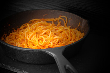 Spaghetti bolognese cooked in a cast iron frying pan.  With lighting effect