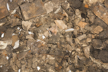 Home destruction background. Chimney demolition texture. Cracked bricks on dirty ground. Crushed stone background. Old house full renovation.