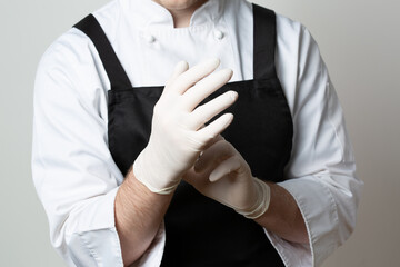 Chef putting latex gloves on. Closeup.