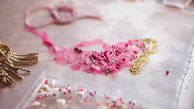 .The embroiderer at work. Couture embroidery of floral motifs
