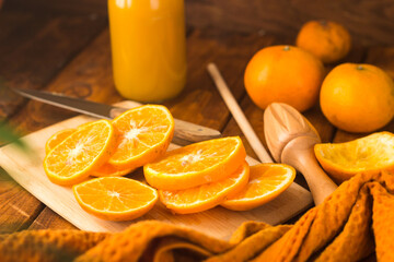 sliced oranges on a chopping board on a wooden table in the kitchen. Squeezing juice from oranges