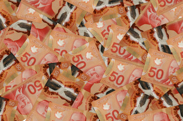50 Canadian dollars bills lies in big pile. Rich life conceptual background