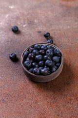 blueberries in a bowl on table, healhty food,  fresh blueberry on dark stone background