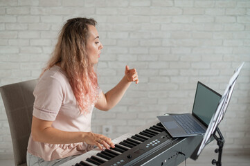 Remote music lessons. A singing teacher records the lesson on a laptop webcam.