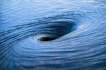 The raging whirlpool. Huge whirlpool on a water surface - 403794243