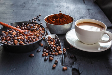 .Roasted coffee beans with coffee powder and coffee cups.