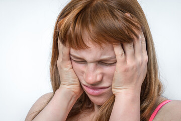 Woman with headache or migraine is holding her aching forehead