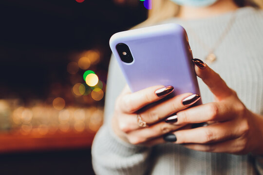 Female Hand Holding Purple Phone In Clear Silicone Case Isolated. Clear Phone Case Mock Up Back View.