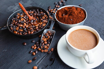 .Roasted coffee beans with coffee powder and coffee cups.