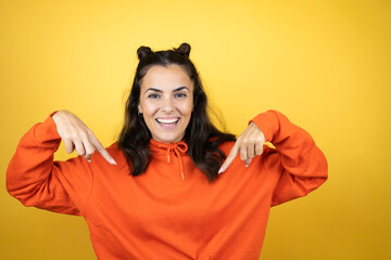 Young beautiful woman wearing sweatshirt over isolated yellow background looking confident with...