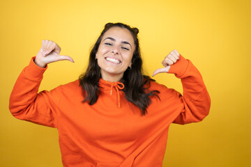 Young beautiful woman wearing sweatshirt over isolated yellow background looking confident with...