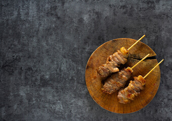 Flat lay image BBQ pork grilled on a wooden cutting board, is a hot food style background served with spices with copy space for text.