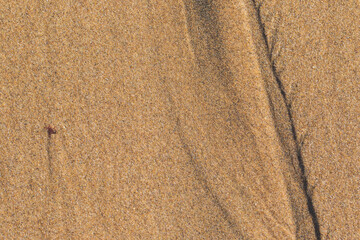 Extreme macro close up of fine beach sand surface pattern in the summer. Sandy trails, texture and background. Top view. Abstract Background. 