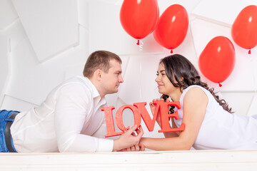 valentine's day, a couple in love holds a large inscription Love