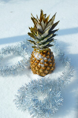 pineapple in the snow with Christmas tree tinsel