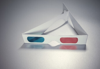Cardboard stereo 3D glasses with red and blue lenses for viewing three-dimensional movies. On the silvery isolate.
