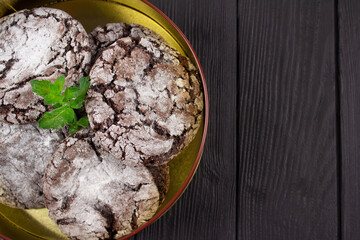 Closeup of homemade chocolate cookies in metal container on black wooden table background with copy space for text or recipe. Handmade traditional cookies on rustic table, selective focus
