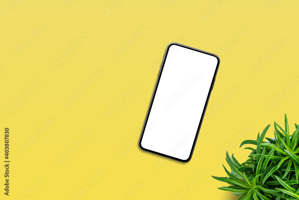 Poster Phone on yellow table with plant beside. Top view, flat lay composition with copy space. Isolated screen for app or web site design promotion