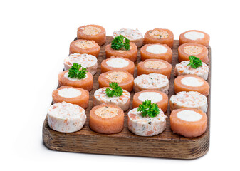 Smoked salmon assorted canapes on wooden board isolated on white