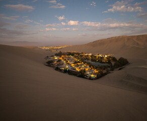 Panoramic postcard view of Huacachina oasis town village desert dry sand dunes texture pattern Ica...