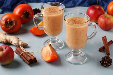 Homemade smoothie of persimmon with cinnamon on light blue background, horizontal format, Closeup