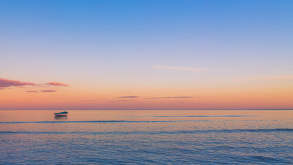 boat on calm ocean at sunset, background