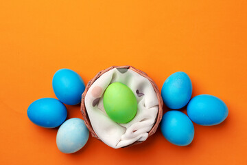 Easter eggs in a nest on orange background