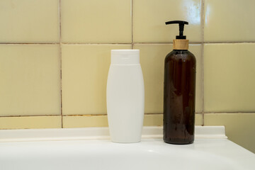 Closeup of shampoo and liquid soap dispenser  on a white bathroom sink