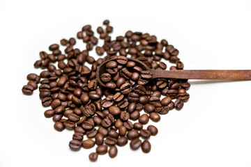 Coffee beans in wooden spoon. White background.