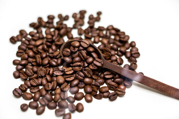 Coffee beans in wooden spoon. White background.