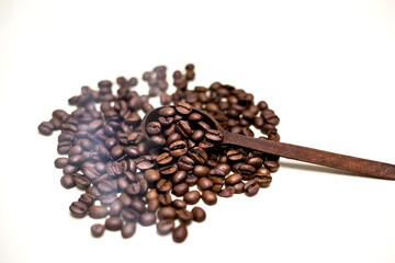 Coffee beans in wooden spoon. White background.