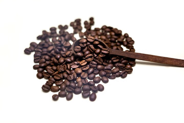 Coffee beans in wooden spoon. White background.