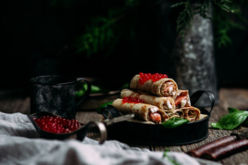 Pancakes with red caviar and salmon in a plate. Maslenitsa holiday