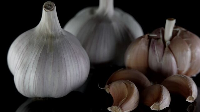dry bulbs of garlic on black table, spices for cooking, traditional medicine cure