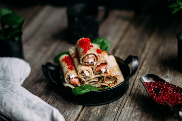 Pancakes with red caviar and salmon in a plate. Maslenitsa holiday