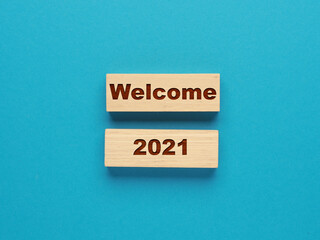 Two wooden blocks with the inscription Welcome 2021 on a blue background, New Year's concept, Start...