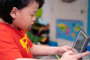 asian boy use tablet online learn from home