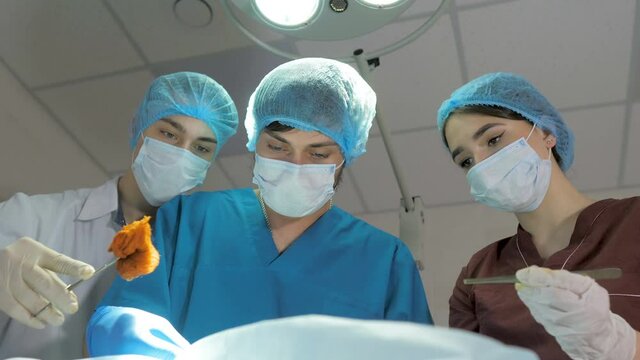 Surgeons are operating. Resuscitation medicine team wearing masks holding medical tools