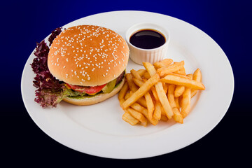 Fresh tasty burger with a Patty made of beef with tomato, cheese, cucumber with a side dish of French fries and sauce.
