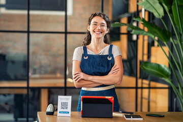 Successful small business owner standing at cash register - obrazy, fototapety, plakaty