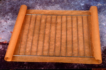 Empty metal grill on baking paper, Rustic background. Empty grill grate