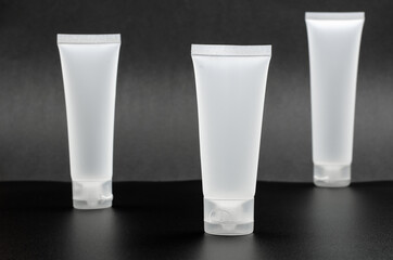 Natural organic cosmetics concept. Mockup, top view. White tube for cream on a black background.
