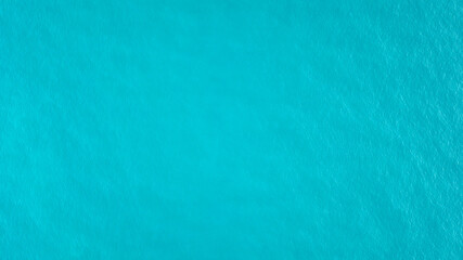 Top view of the turquoise water. Like a background. Small waves create ripples on the sea and change color. Gradient from turquoise to dark blue in places. Clean ocean. The background photo. Thailand.